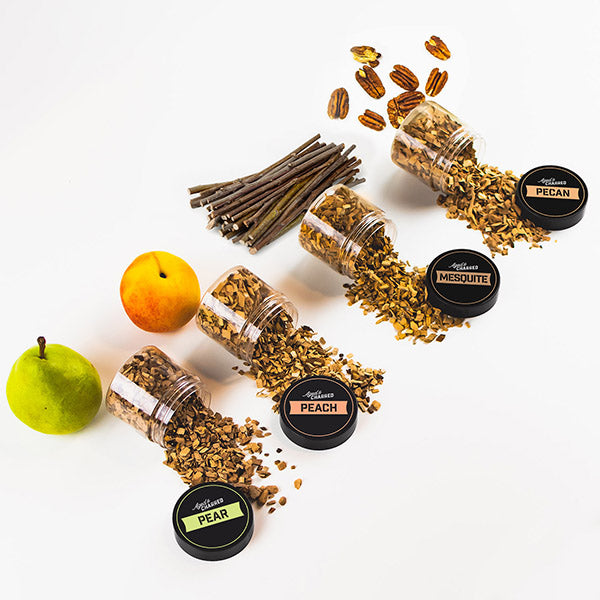 Four containers labeled peach, pear, mesquite, and pecan, containing wood chips for cocktail smoking.