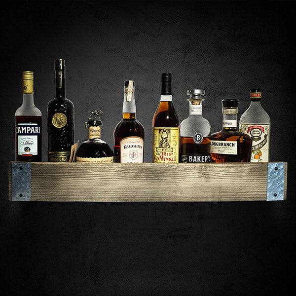 Whiskey bottles placed on a barrel stave wall shelf