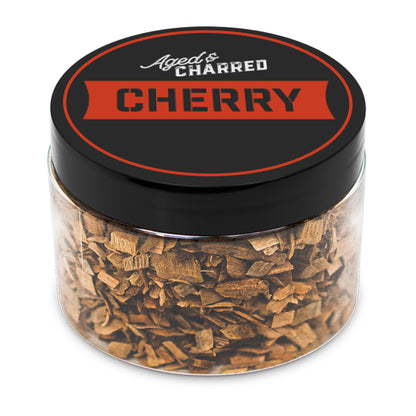 A clear container filled with cherry wood chips, with a black lid featuring the text 'AGED & CHARRED CHERRY'