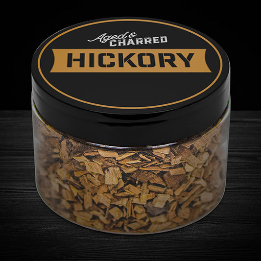 A clear container filled with Hickory wood chips, intended for whiskey infusion.