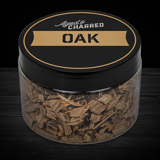 A clear container filled with oak wood chips, labeled 'Aged & Charred OAK'