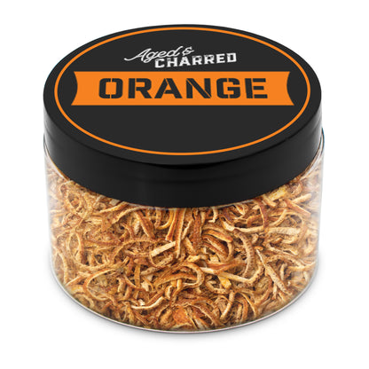 A clear container filled with aged and charred orange peel, with a black lid featuring the text 'AGED CHARRED ORANGE' on it.