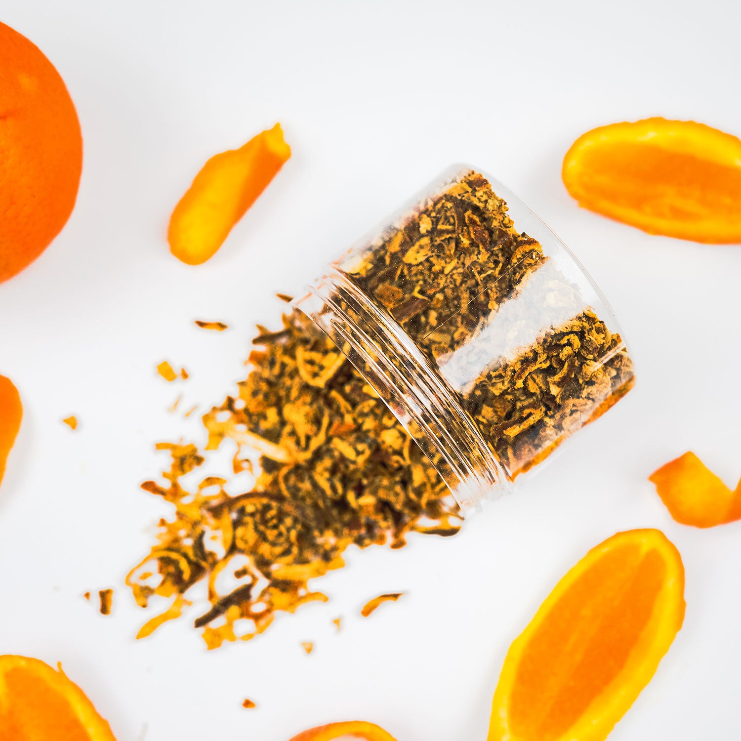 A clear container filled with aged and charred orange peel spilled