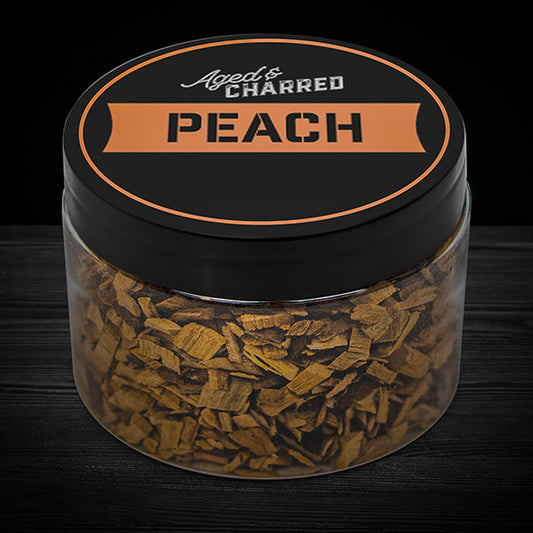 A clear container filled with peach wood chips, labeled 'AGED & CHARRED PEACH'.