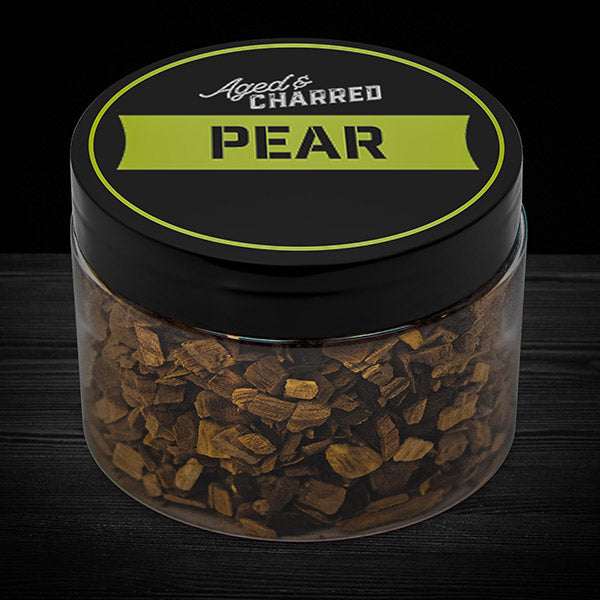 A clear container filled with pear wood chips, intended for whiskey infusion.