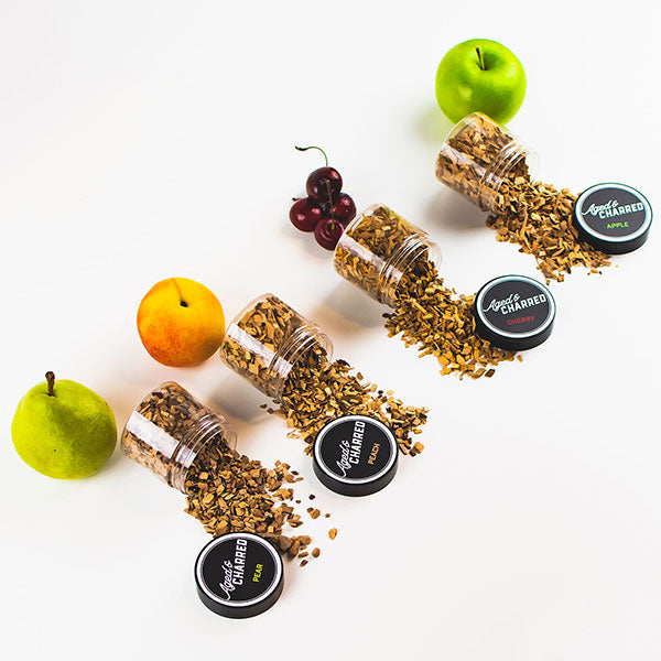 Four containers labeled Aged & Charred with different wood types spilled: apple, cherry, pear, and peach